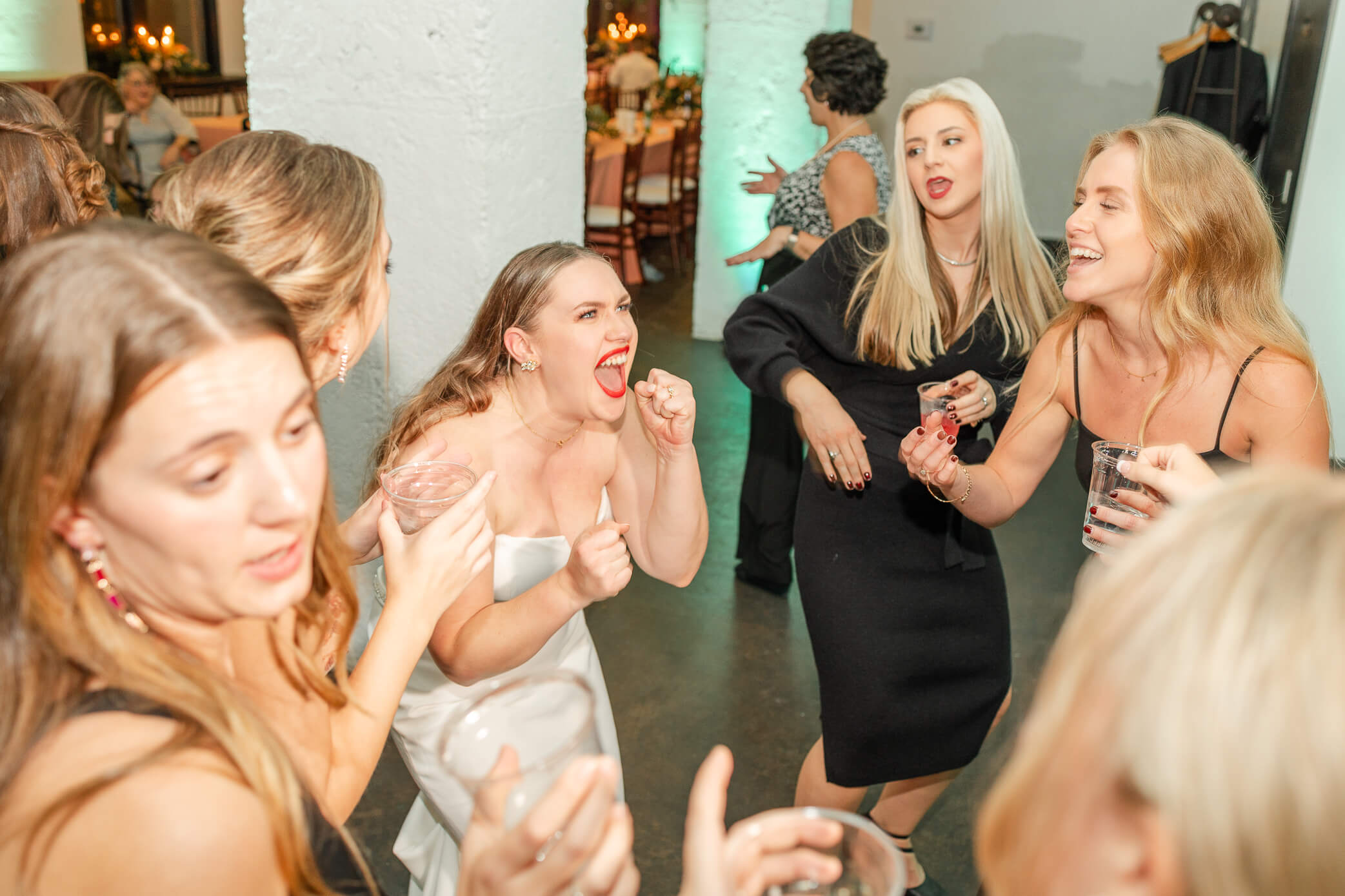 Bride dancing and singing with her guests at her wedding reception. 