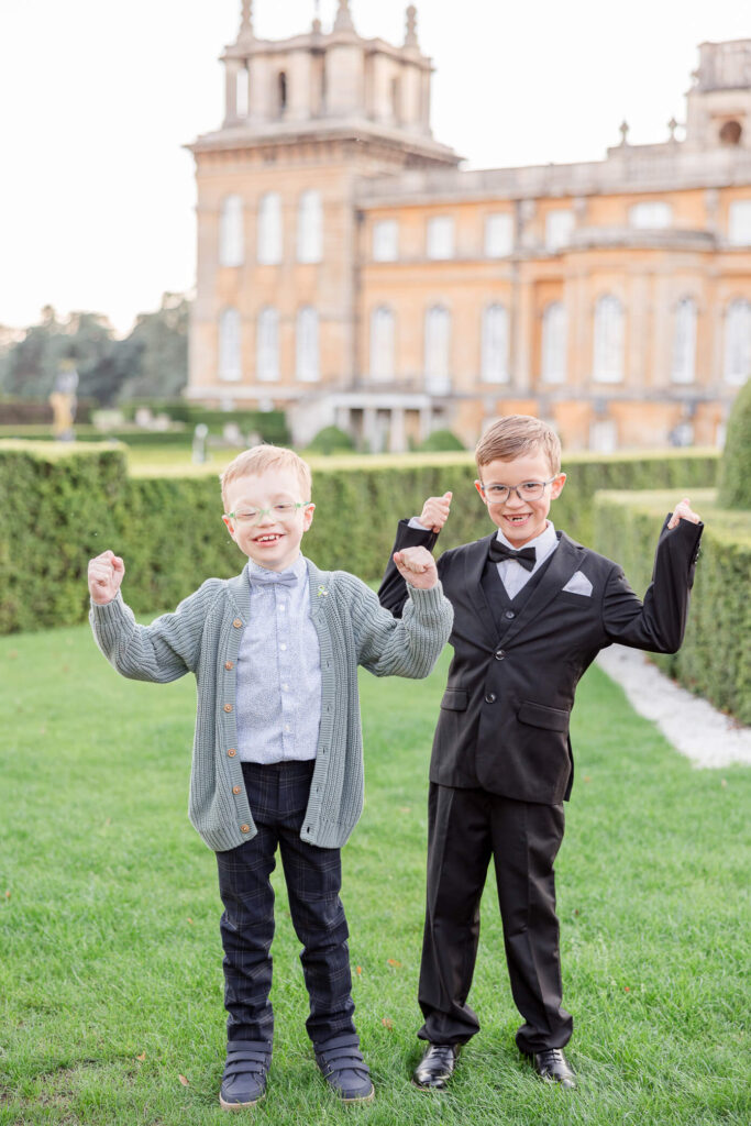 Two young boys stand next to each other and show off their muscles at an event at Blenheim Palace