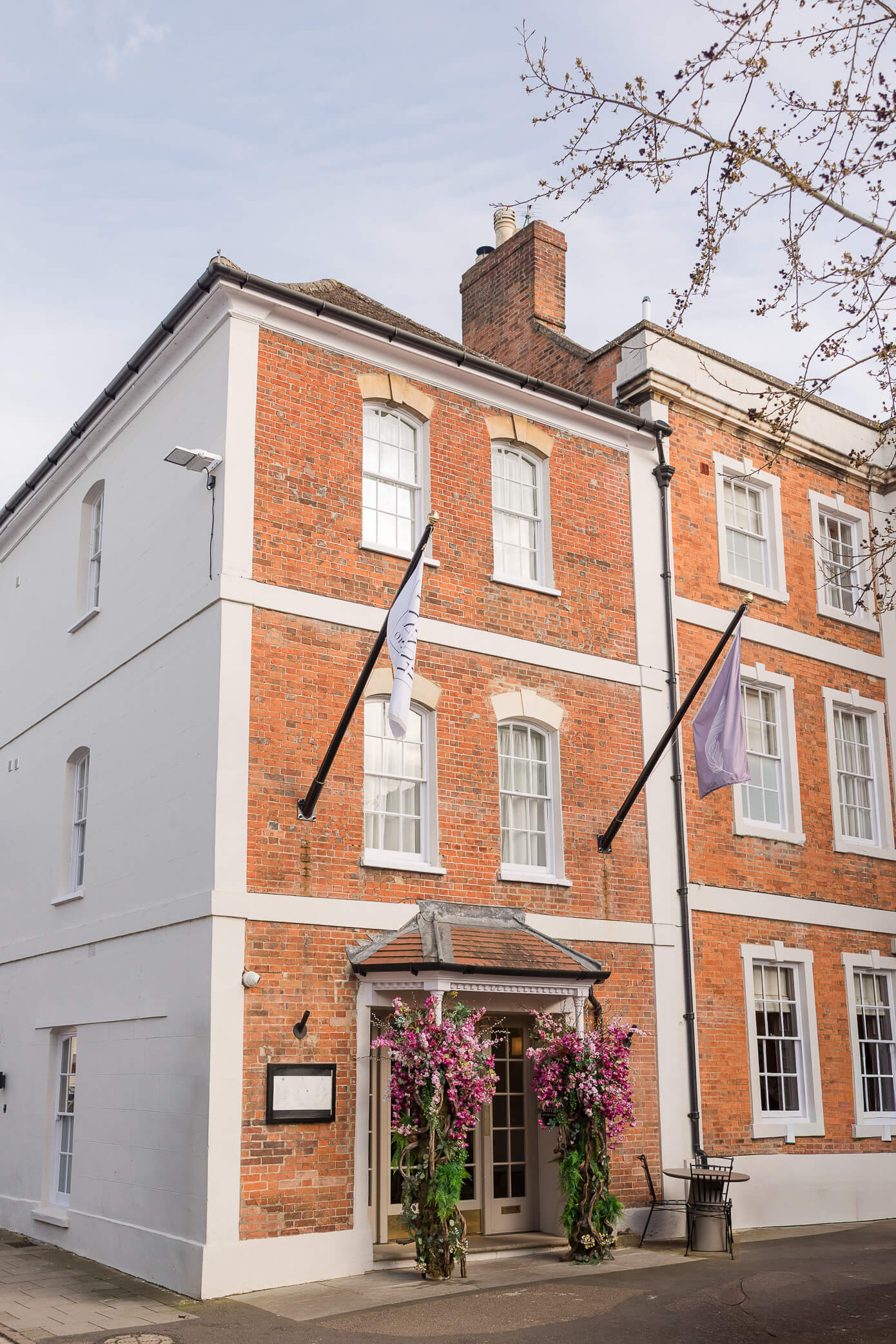 The Feathers Hotel in Oxfordshire with a big pink and green floral display on the door