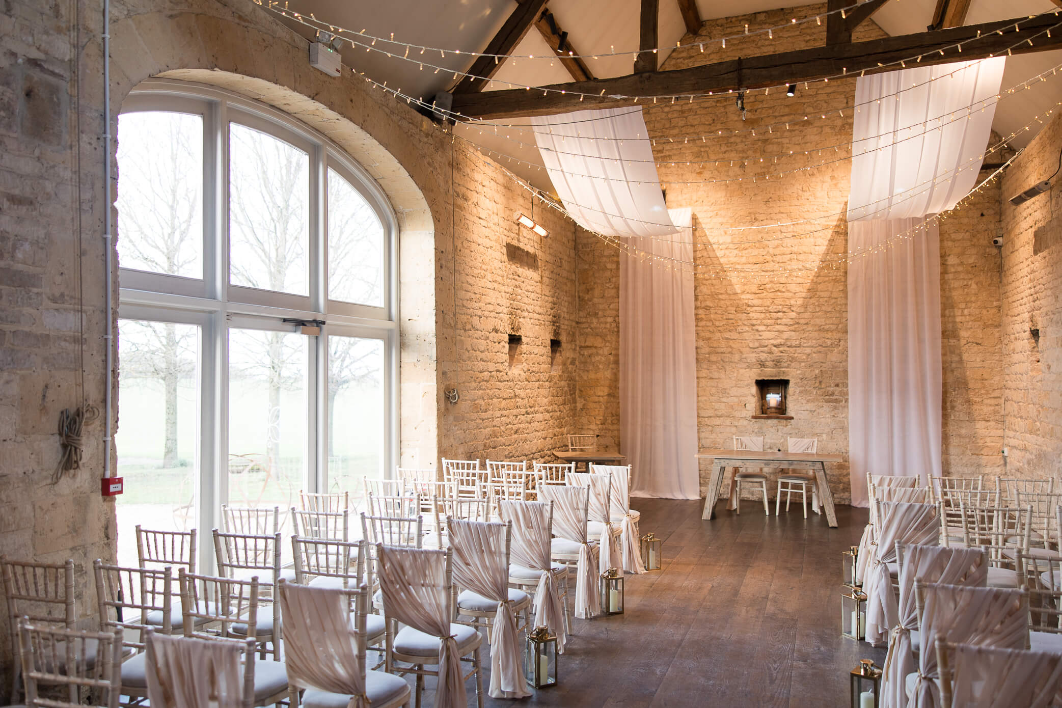 Ceremony setup at Lapstone Barn wedding venue with chairs and a big window letting in natural light.