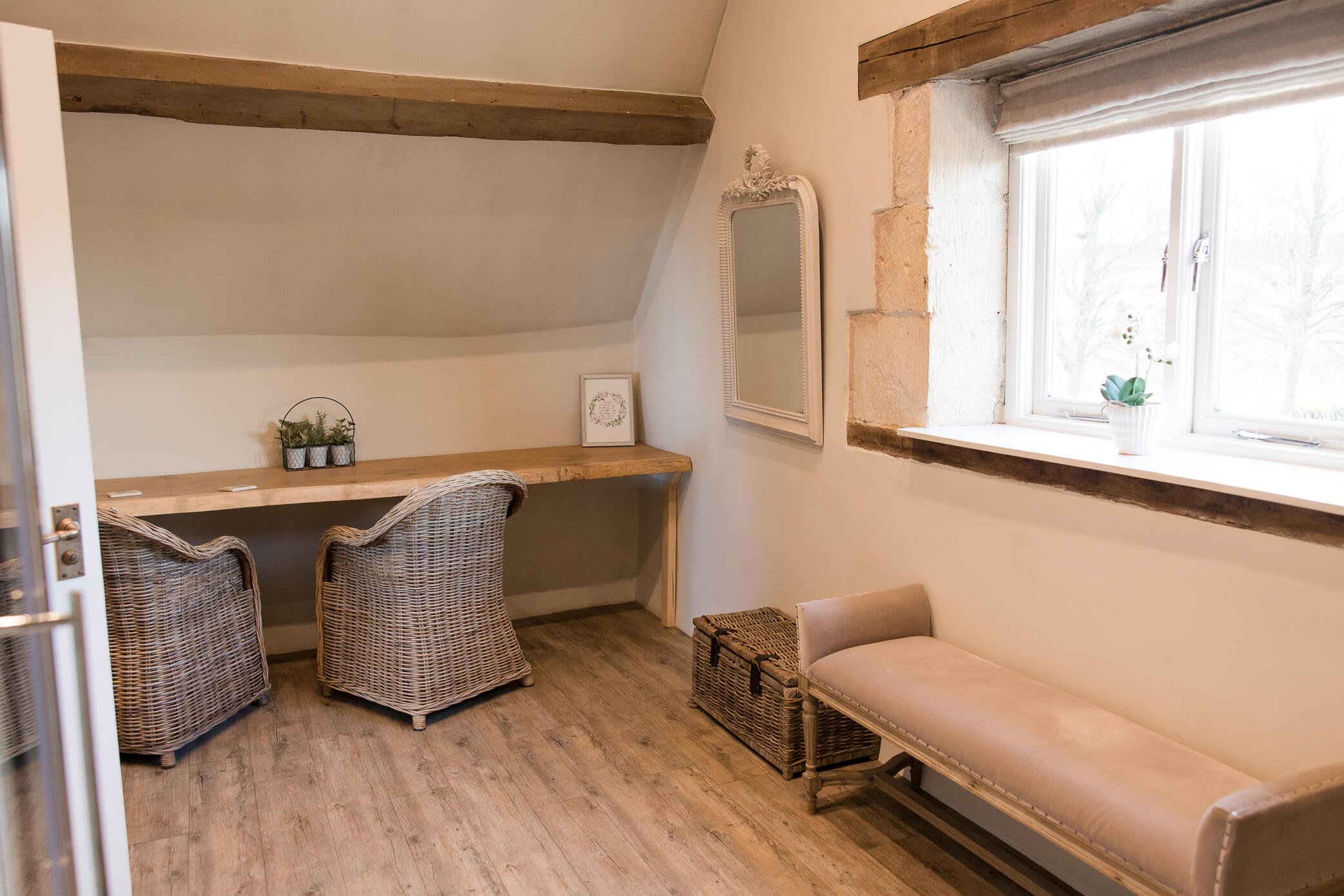 The shower room with desk, chairs, and a bench by a window.