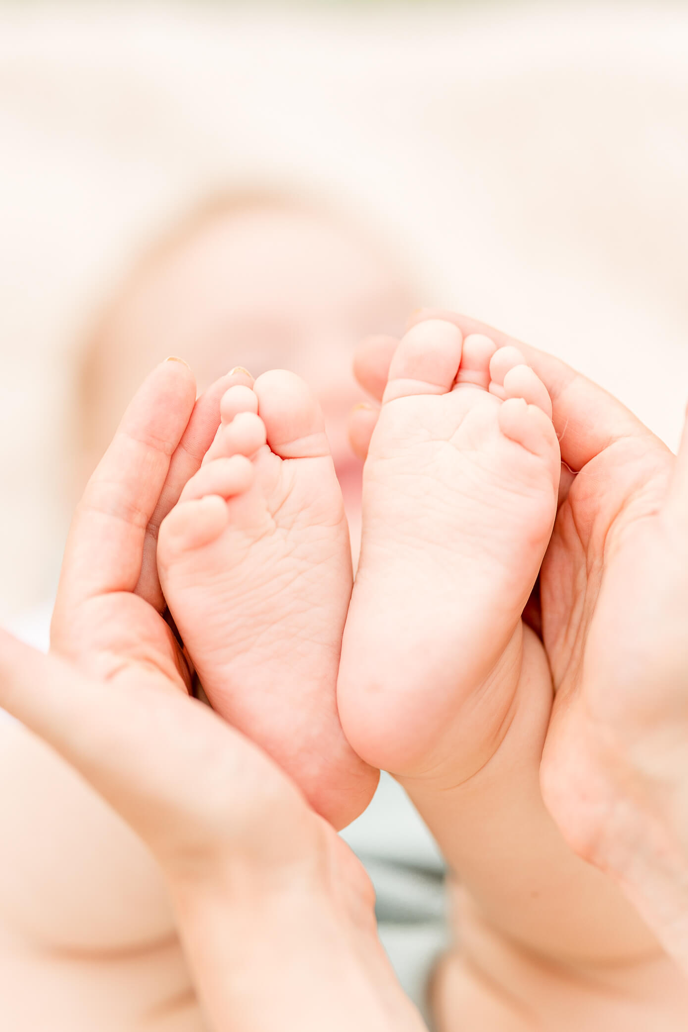 A mother cups her baby's feet in her hands after visiting the Woodstock pediatricians 
