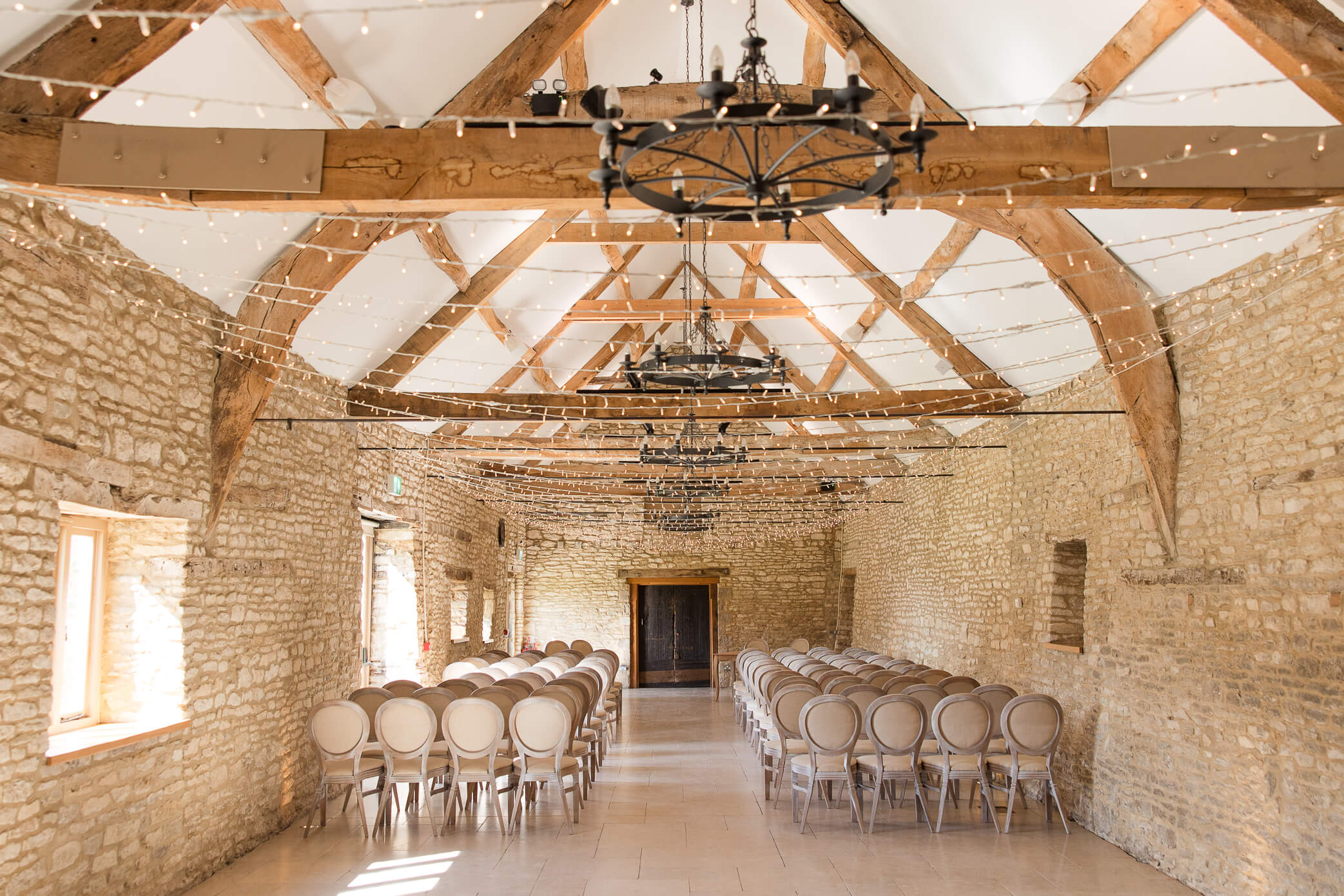 Caswell House barn set up with chairs and fairy lights for a wedding