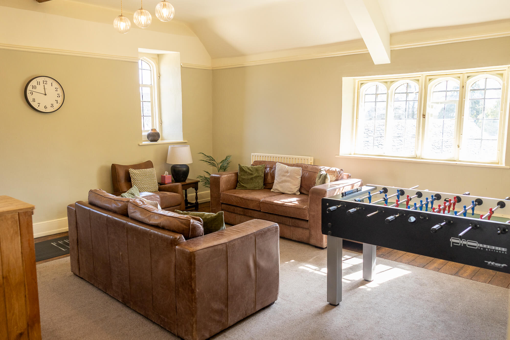Groom prep space at Caswell House equipped with comfortable leather couches, a mini bar, and games to play