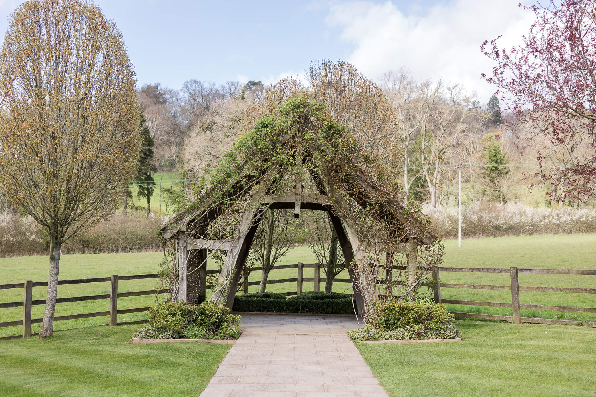 The Arbour, which is a gazebo-type of structure that can host wedding ceremonies on nice days in the back garden. In the summer, it is covered with climbing roses