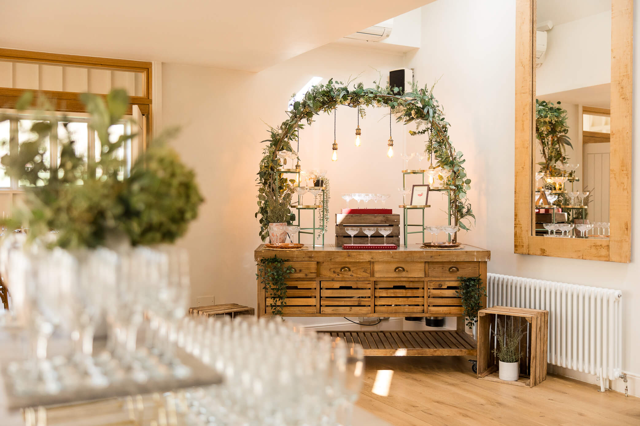 A drinks cart with glasses set up in beautiful, tiered way and ready for use