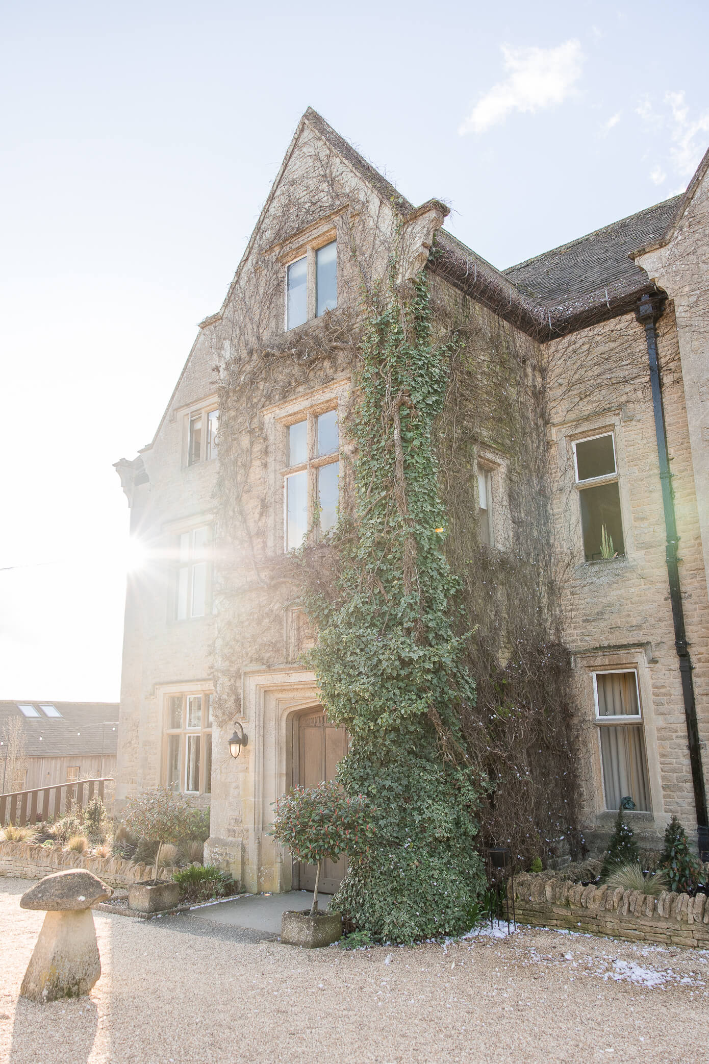 The sun setting on the side of Hyde House and creating a flare against the stone