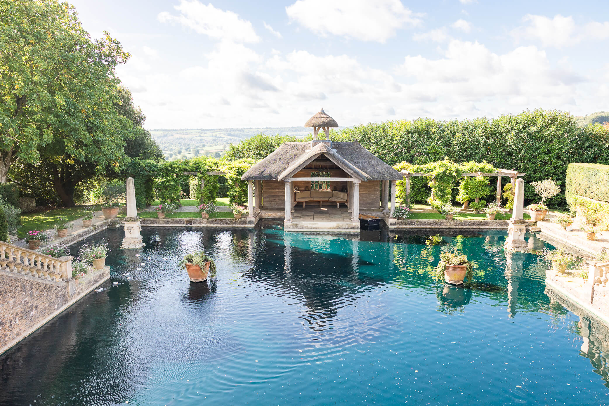 the boathouse at Euridge Manor with teal water in the lake in front of it